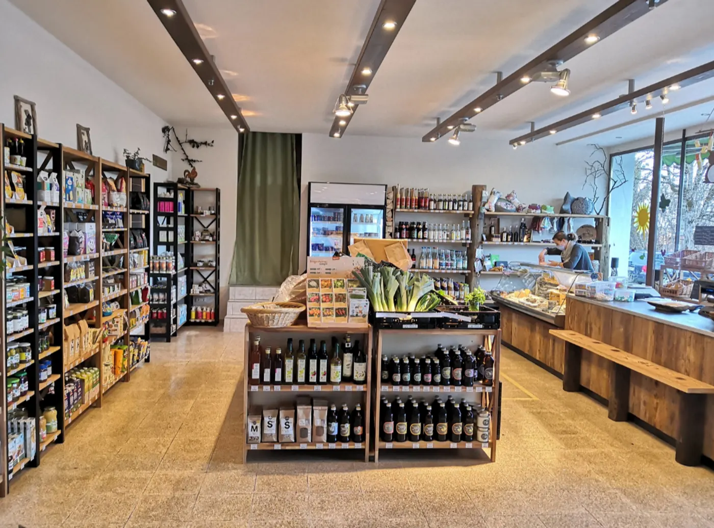 Blick in den Dorfladen NaturSach mit Holzregalen, Weinregal und Obsttheke